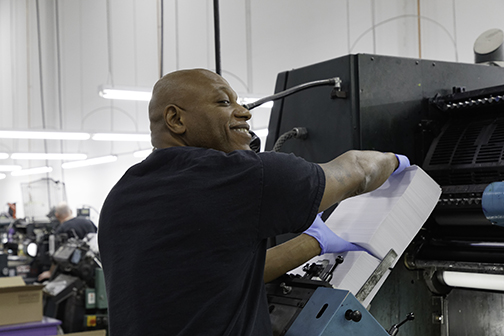 Man smiling while working on a machine - packaging website