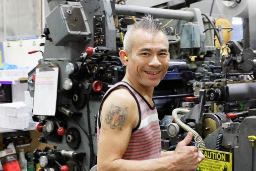 Man smiling and giving a thumbs up in a warehouse - promotional packaging