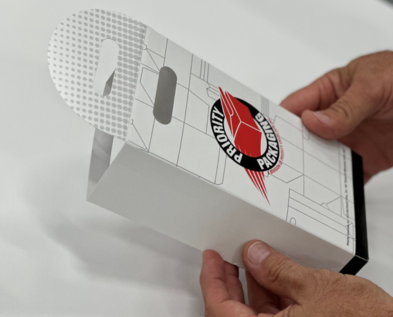 A person holding paper packaging with priority envelope logo - box