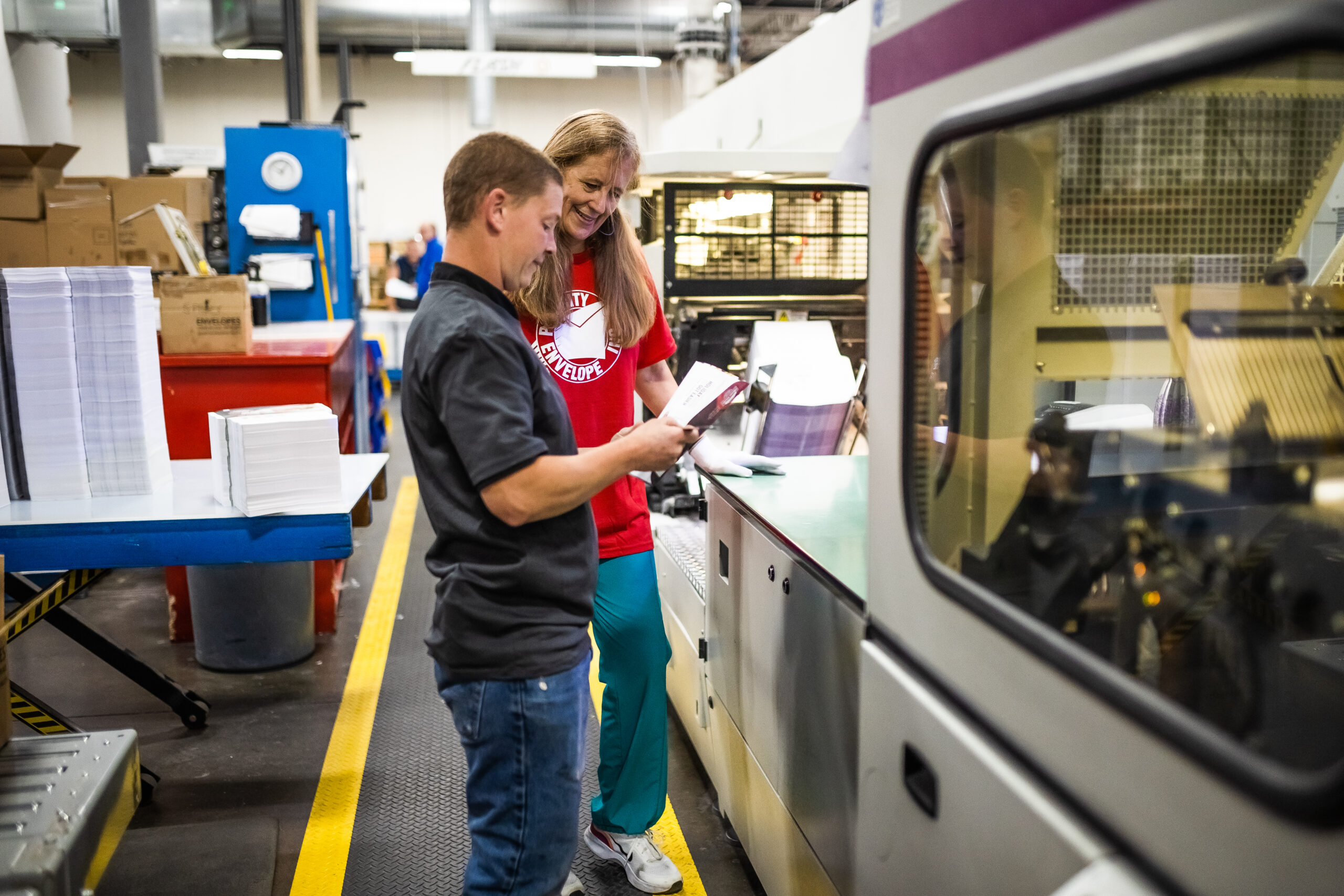 two people reviewing a handbook in a warehouse - custom envelopes